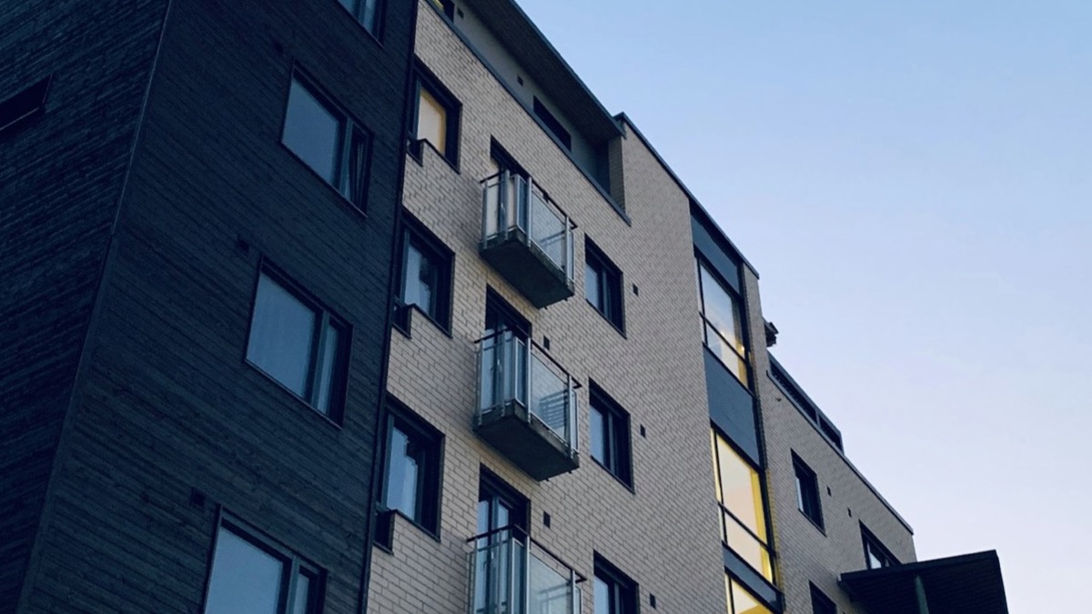 A modern apartment building exterior with balconies at dusk